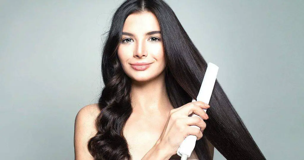 an image of a beautiful woman using one of the best hair straightener for fine hair Australia