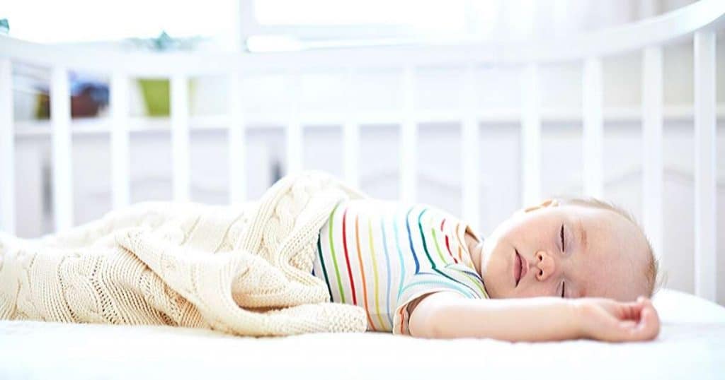 an image of a baby sound asleep in their cot