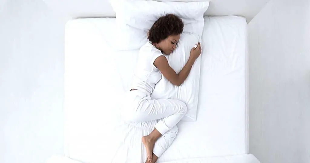 an image of a woman sleeping on the best memory foam topper
