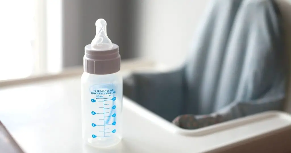 A highchair with the best milk bottle for baby on the tray