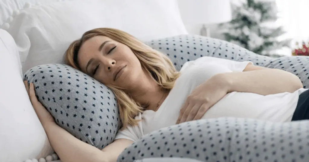 an image of pregnant woman getting comfortable with the best pregnancy pillow
