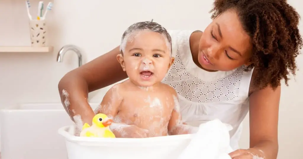 an image of a mum bathing a baby in the best baby bath
