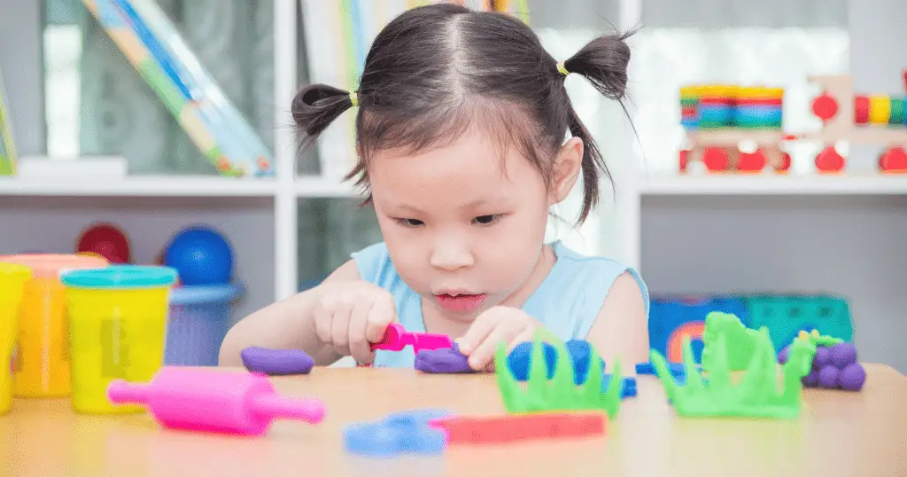 toddler practicing the benefits of playdough for toddlers